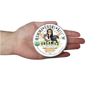 Organic dog paw balms in hand by Momma Knows Best Made in the USA
